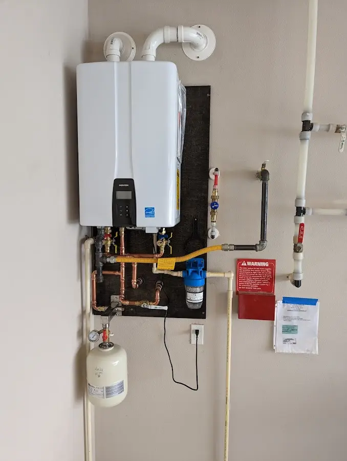 Professional plumber installing copper piping in a Newbury home